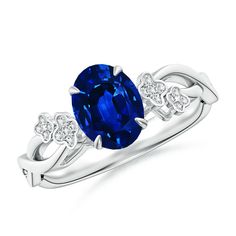 an oval blue sapphire and diamond ring with two diamonds on the band, set in white gold