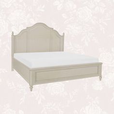 a white bed with a wooden headboard and foot board in front of a wallpapered background