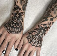 two hands with black and white tattoos on them