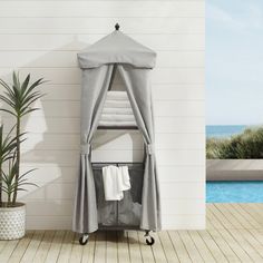 a bathroom with a shower, towel rack and potted plant next to the pool