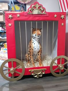 a toy cheetah in a red wagon with gold wheels and stars on it