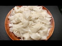 a wooden bowl filled with pasta on top of a table