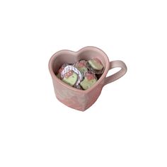 a pink heart shaped mug filled with chocolates