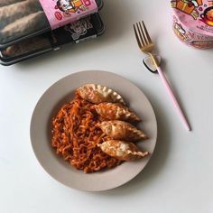 a white plate topped with meat and noodles next to a container of chicken breast patties