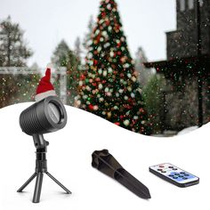 a christmas tree is in the background with a camera and cell phone on a tripod