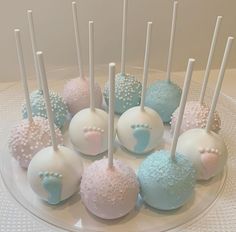 there are many desserts on the plate with white and blue frosted cake pops