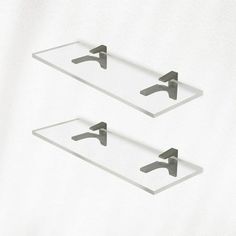 two glass shelves with metal handles on them