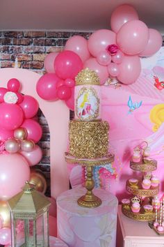 a pink and gold princess birthday party with balloons, cake, cupcakes and decorations