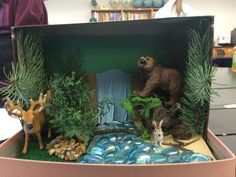 an open cardboard box filled with fake animals and plants