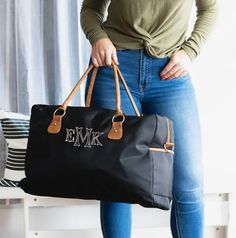 "Travel in style with compliments guaranteed! The Black Nylon Travel Bag features an adjustable/removable shoulder strap, two easy-to-carry handles, and vegan leather accents! Whether you are headed on a mountain-side road-trip or carpooling to the beach, this travel bag is the ultimate companion! 22\" L x 7.5\" W x 14\" H Nylon with Vegan Leather Trim Interior Lining Zipper Closure Easy-to-Carry Handles Adjustable/Removeable Shoulder Strap Reinforced Bottom Embroidered Personalization TURNAROUN Personalized Travel Bag, Carryon Bag, Nylon Travel Bag, Overnight Travel Bag, Weekend Travel Bags, Personalized Luggage, Weekend Bag, Travel Duffel, Travel In Style