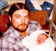 a man holding a baby in his arms