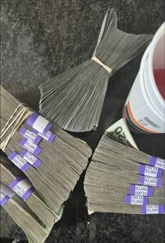 several stacks of money sitting next to a cup of tea