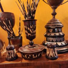 an assortment of decorative vases and bowls on a table