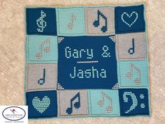 a crocheted afghan with music notes and musical symbols on it, in the shape of a square