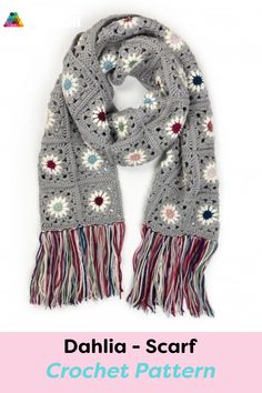 a crocheted scarf with fringes and flowers on the ends, in grey