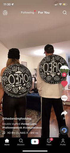 two people standing in front of a mirror holding plates with the words zero on them