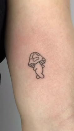 a person with a small tattoo on their arm that has an image of a mushroom