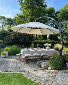 an outdoor dining area with table, chairs and umbrella