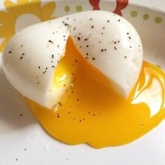 two hard boiled eggs on a plate with mustard and seasoning sprinkles