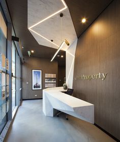 an office lobby with a white counter and black chair in front of the wall that reads unprogetty