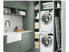 a washer and dryer in a green laundry room with white tiles on the walls