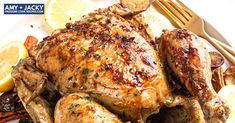 a close up of a chicken on a plate with lemons and other food items