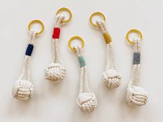 four different types of rope hangings with gold hooks on each side and blue, yellow, red, green, and white ropes