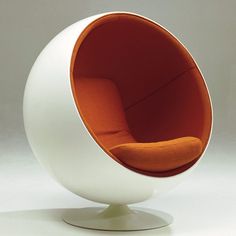 a white ball chair with an orange cushion on it's back and seat in the middle