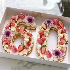 the number 50 is made out of cookies and decorated with strawberries, flowers and leaves