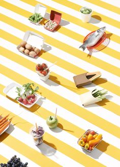 an array of fruits and vegetables on a yellow and white striped tablecloth