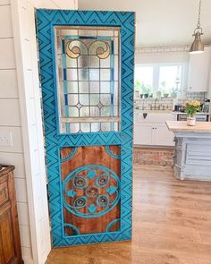 the door is painted blue and has an intricate design on it's glass panel