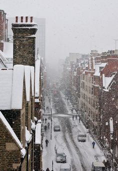 a snowy city street with cars and buildings