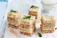 four sandwiches stacked on top of each other next to chopsticks and a cup