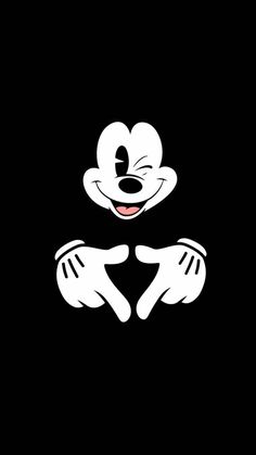 the mickey mouse logo is black and white with two hands on it's chest