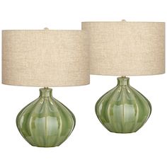 two green vases with lamps on top of them, one has a beige linen shade