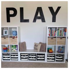 a play room with bookshelves and toy bins on the wall next to it