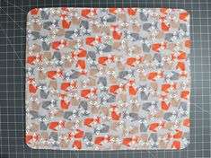 an orange and gray square with foxes on it