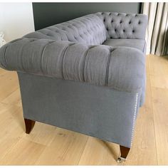 a grey couch sitting on top of a hard wood floor