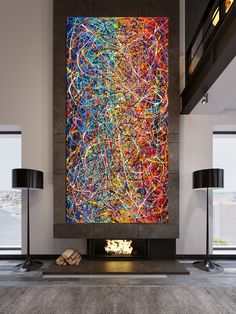 a large abstract painting on the wall in a living room next to two black lamps