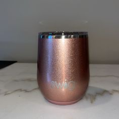 a pink wine cup sitting on top of a white marble counter next to a wall