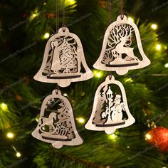 three wooden bell ornaments hanging from a christmas tree