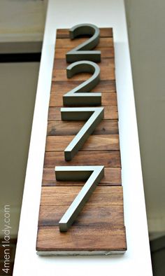 a wooden sign with the number twenty seven on it's front and back sides