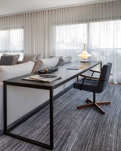 a living room filled with furniture and a table in front of a window next to a couch