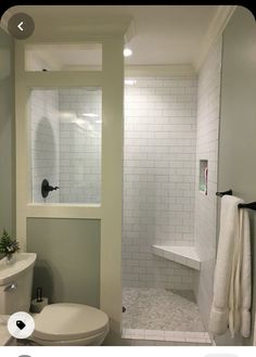 a white toilet sitting next to a walk in shower