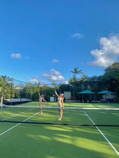 two people are playing tennis on a sunny day