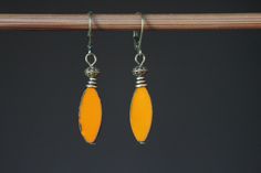 Orange Earrings Glass Earrings Dangle Earrings Drop earrings Gift for her Gift for women  Color : Pumpkin Orange 20x9mm Table Cut Spindle Beads, Picasso Finish, Pointed Oval, 20x8mm, Czech Republic Glass Beads Finish : Antique Brass findings Length : 1 6/8 inches including the antique Brass lever back Ear wires : Antique Brass lever back Glass Earrings section : https://www.etsy.com/shop/NtikArtJewelry?ref=hdr_shop_menu&section_id=16062218 To visit my shop : https://www.etsy.com/shop/NtikArtJewelry Thanks for looking Yellow Dangle Earrings With Lever Back, Red Earrings Dangle, Red Flower Earrings, Autumn Earrings, Turquoise Jewelry Earrings, Czech Glass Jewelry, Small Dangle Earrings, Rustic Earrings, Boho Chic Earrings