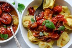 two bowls filled with pasta and tomato sauce