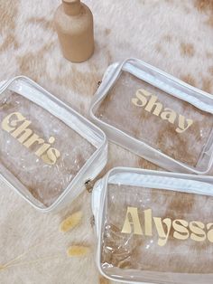 three clear plastic containers sitting on top of a white fur covered floor next to a vase