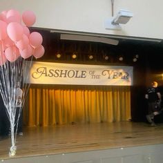 balloons are floating in the air near a stage with a sign that reads, ashhole of the river