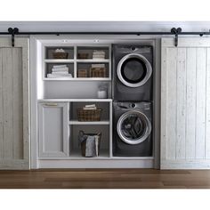 a washer and dryer in a room with white walls, open shelving